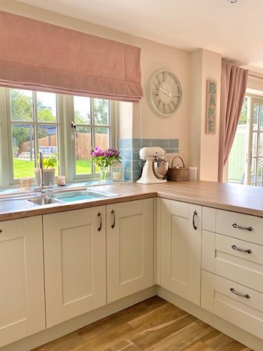 #mysymphonystyle September competition winner kitchen, ivory cabinets with a light wood effect laminate worktop with window and clock