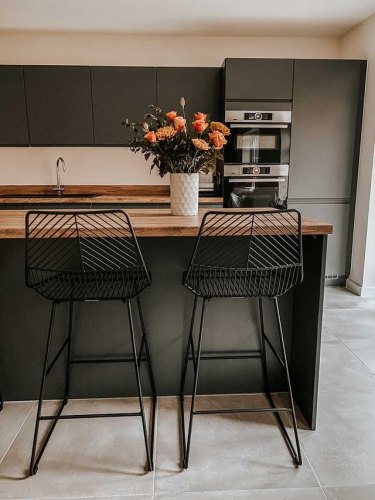 kitchen of MySymphonyStyle November winner. A dark grey anthracite kitchen with wood worktops and black barstools at a breakfast bar. A flower vase features on the kitchen island